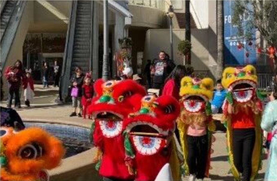 Yamei Academy students performing a lion dance parade at a community celebration